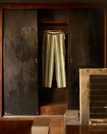 Green and white striped pants on a hanger inside a cabinet of the Rose House