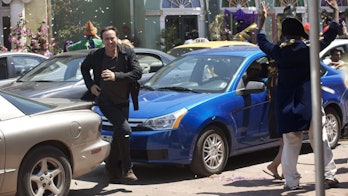 Nicolas Cage runs through the streets of New Orleans during Mardi Gras.