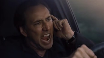Cage in his car yelling on his phone.