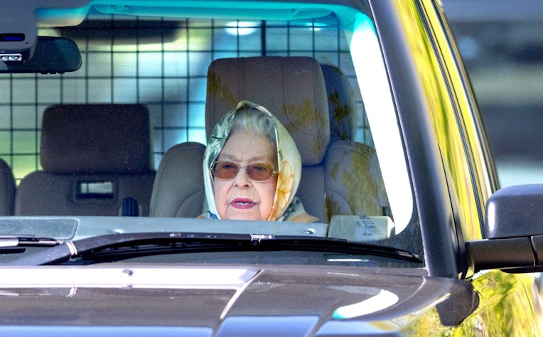 Queen Elizabeth in the passengers seat of an older car.