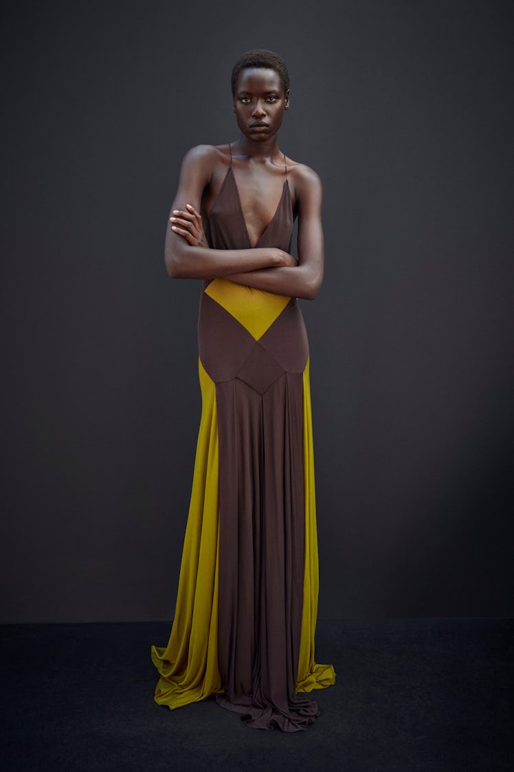 A model posing in a brown and yellow Saint Laurent dress