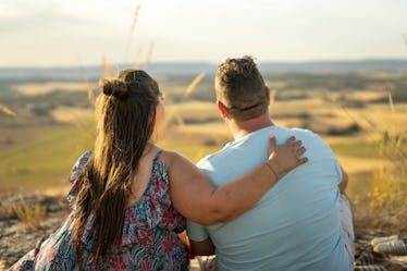 A happy fat couple looks out at scenery.