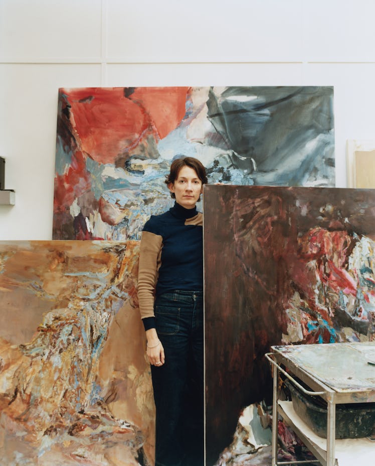 Francesca, standing amongst her paintings in her studio in London.