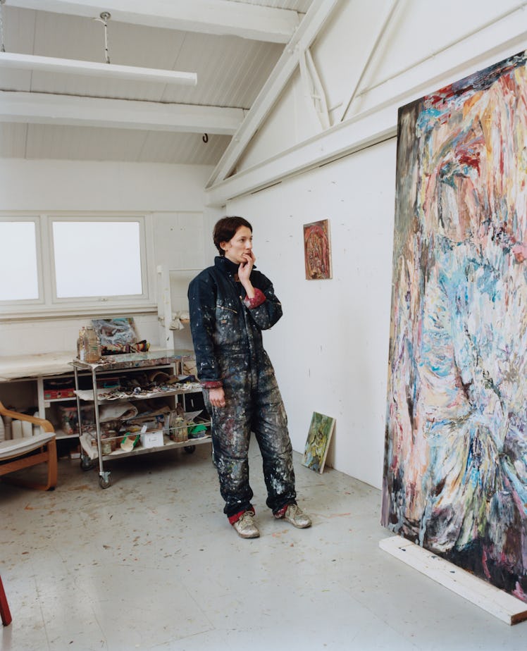 Francesca looking at a work on the wall in her studio