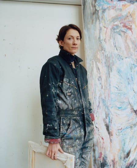 A portrait of Francesca Mollett in front of one of her works in her studio in London