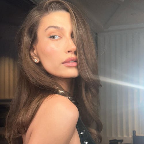 Hailey Bieber over shoulder brunette side part