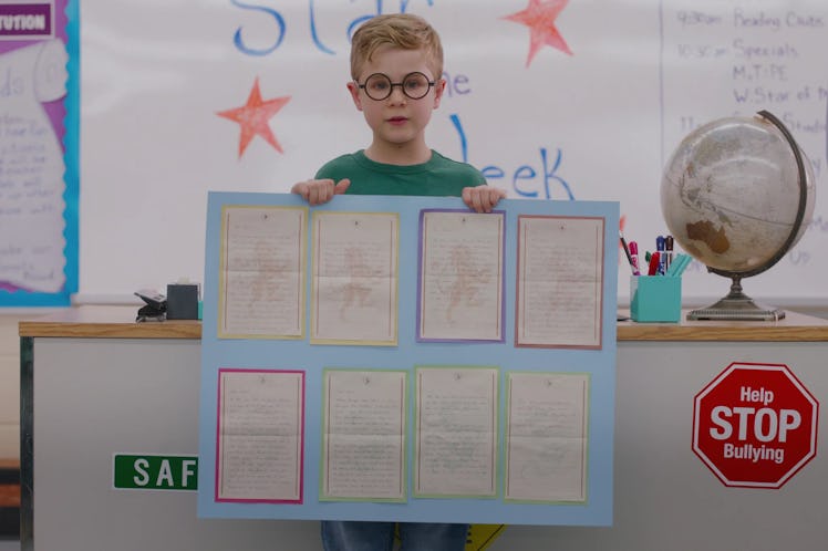 Austin, a Scorpio, played by Diesel La Torraca, holds up a school project in class during Ginny & Ge...