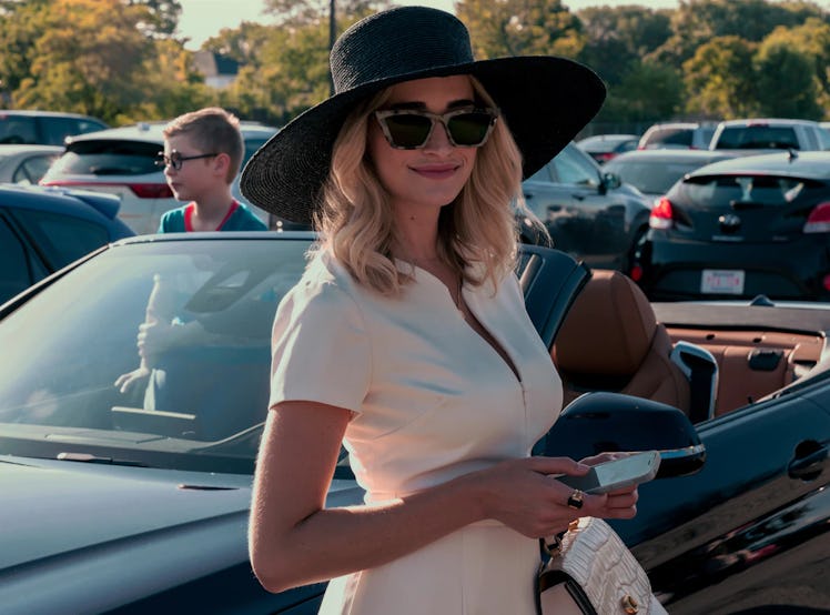 Georgia, an Aries, played by Brianne Howey, smiles while wearing a hat and glasses during Ginny & Ge...