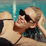 Miley Cyrus lounging by the pool in a black bra and underwear