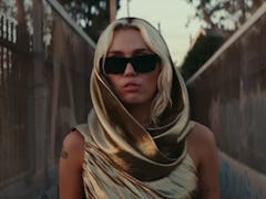 A shot of Miley Cyrus in her "Flowers" music video, which fans are asking where was Miley Cyrus' "Fl...