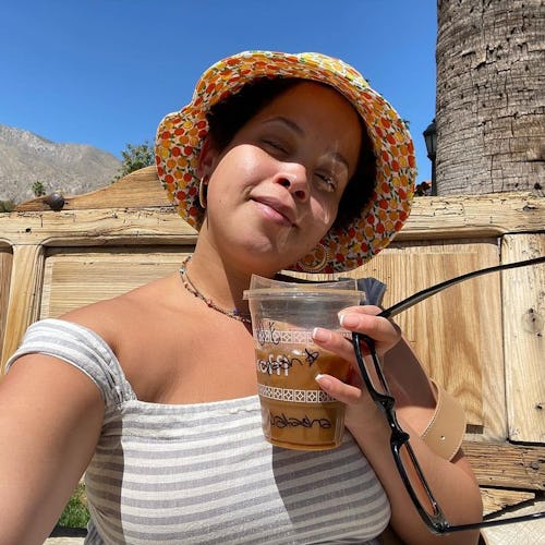 Beauty writer Natasha Marsh wearing a bucket hat and striped top on a sunny day. 
