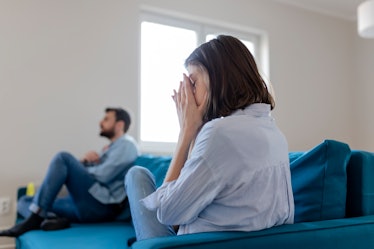 Woman on couch looking at husband with frustration