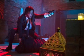Keanu Reeves points a gun in a brick-walled nightclub in 2014's John Wick