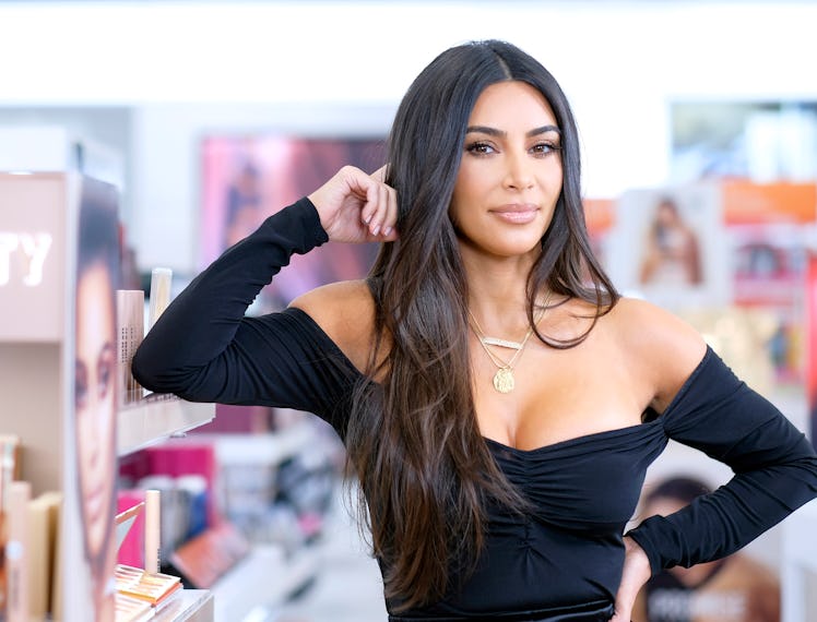 Kim Kardashian posing for the camera in a black bodysuit