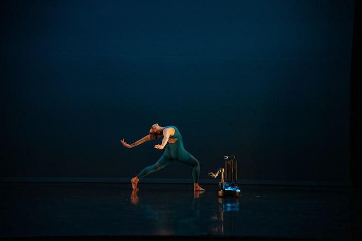 An image of a dancer performing with a robot in "Amelia and the Machine" at Virginia Commonwealth Un...