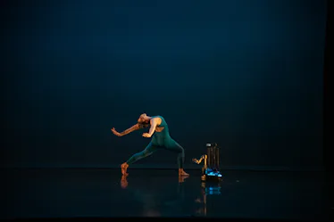 An image of a dancer performing with a robot in