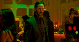 Keanu Reeves stands under a green light as John Wick