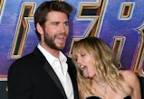 miley cyrus licks liam hemsworth on the red carpet, causing liam to tell her to "behave'