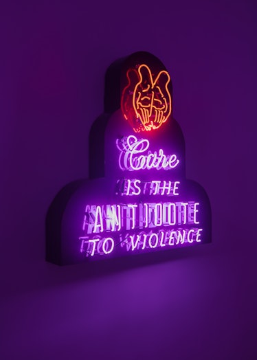 neon lights that say care is the antidote to violence