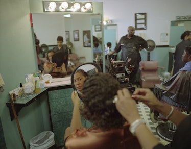 a photograph of a woman in the salon chair getting her hair done looking in the mirror