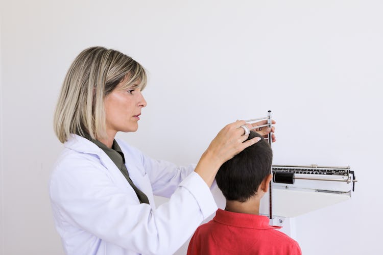 pediatrician measuring height and weight of a child