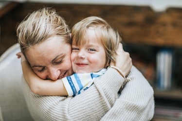 Woman affectionately hugging smiling child