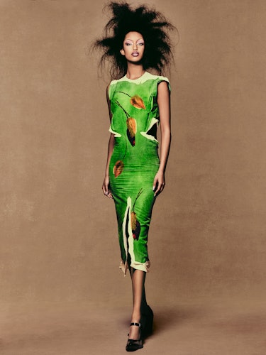 Model Mona Tougaard wears a green dress with a leaf design and shoes.