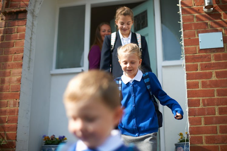 A mom says goodbye as her three schoolkids leave their house.