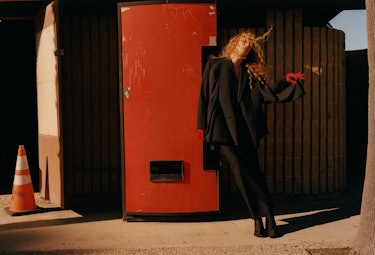 Raquel Zimmermann wears a black jacket, skirt and boots.