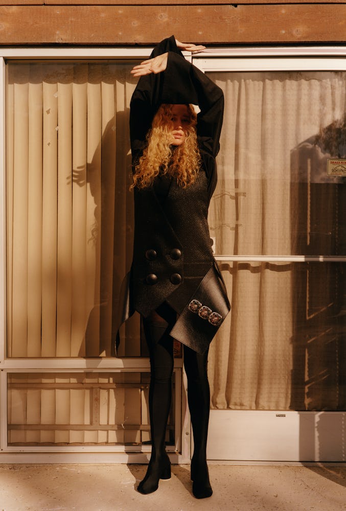 Raquel Zimmermann wears a black leather dress and boots.