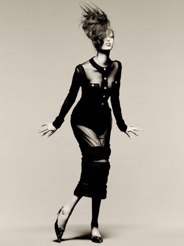 Model Mona Tougaard wears a black sheer dress and shoes.