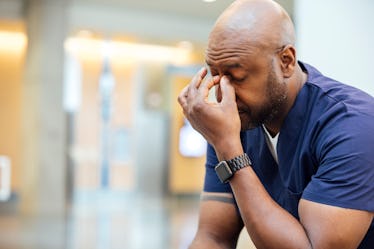 Stressed out middle aged man pressing fingers to nose