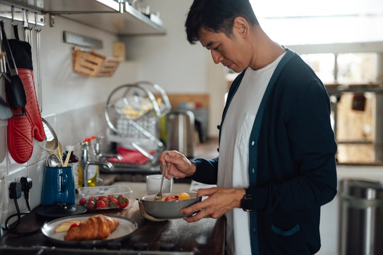 A man preparing breakfast in his kitchen.