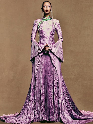 Model Mona Tougaard wears a purple gown, headpiece and earrings.