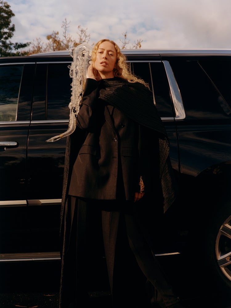 Raquel Zimmermann wears a black suit and scarf.
