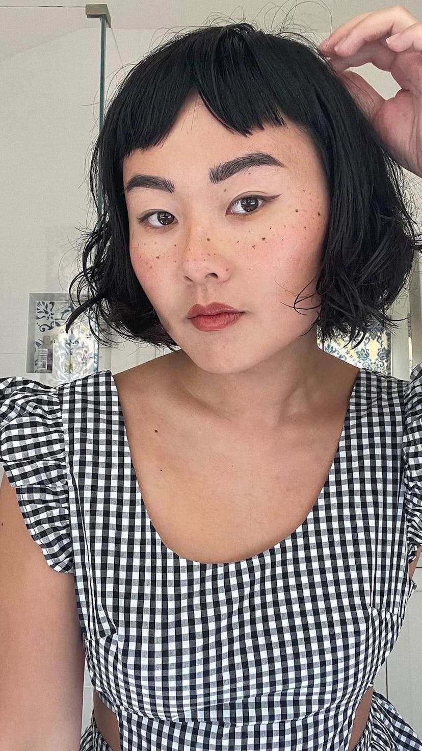 A woman with a wavy French bob and micro bangs.