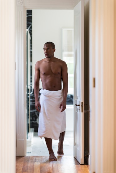 A shirtless man in a towel on his lower half.