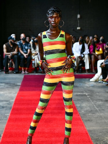 Model Dosha Deng wears a colorful bodysuit and hoop earrings.