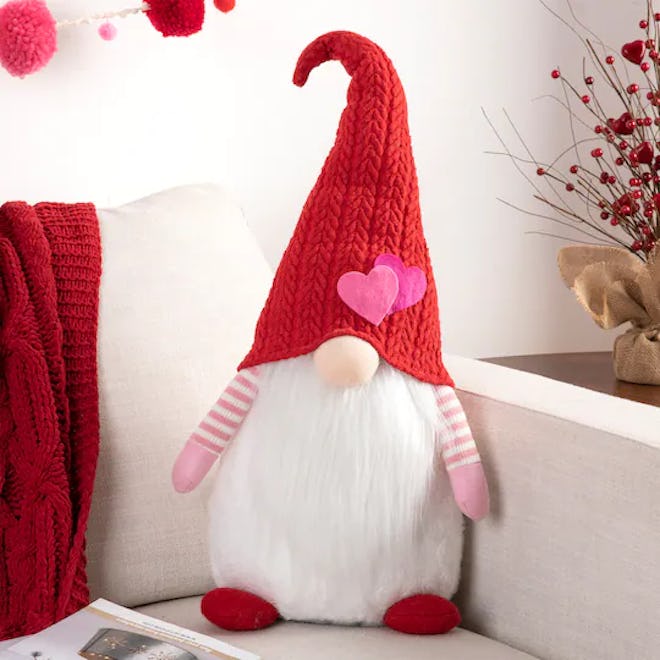 Plush gnome with a heart hat, meant to be used as Valentine's Day decor
