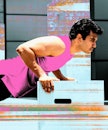 一个穿着粉色背心的男人在健身房做腹肌锻炼