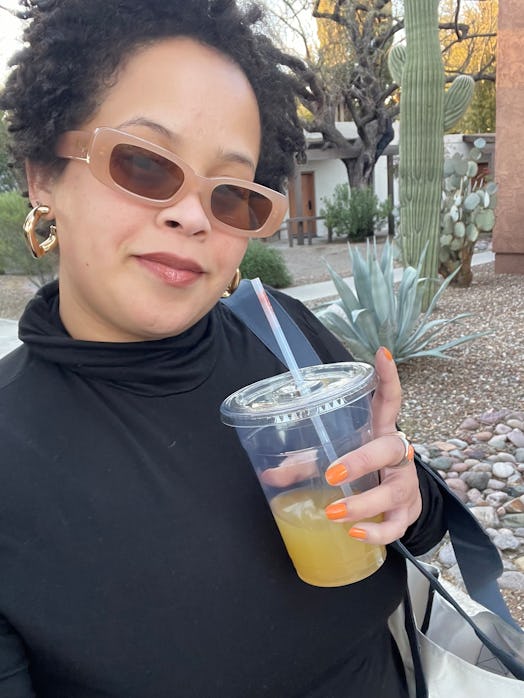 Natasha drinking a beverage outdoors