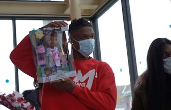 Buffalo Bills player Damar Hamlin holds up a packaged toy in a still image from his 2020 toy drive v...