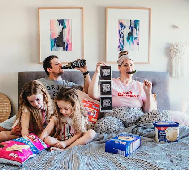 family in bed eating food for a funny pregnancy announcement 