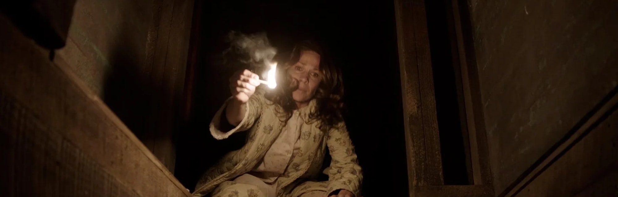 Lili Taylor holds a lit match as Carolyn Perron in 2013's The Conjuring