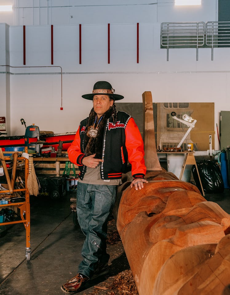 the artist Nicholas Galanin with his new totem, carving in progress. 