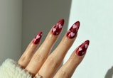 Red nails with pink hearts are a simple heart nail art design for Valentine's Day 2023.