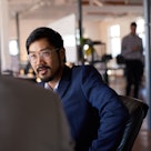 Man in glasses talking to boss in office setting