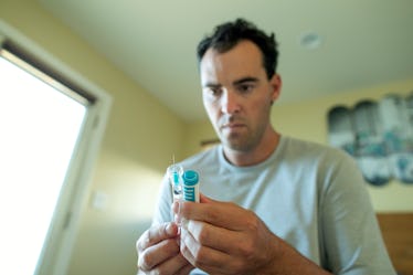 A man looks at his testosterone replacement therapy injection.
