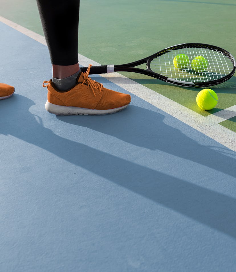 close-up of an orange tennis shoe on a tennis court