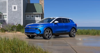 An image of the 2024 Chevrolet Equinox EV in front of a lakeside home.